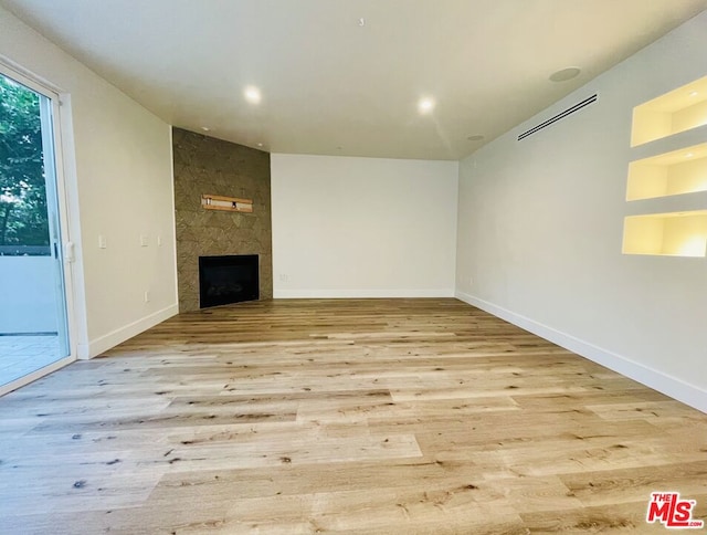 unfurnished living room with light wood-type flooring and a fireplace