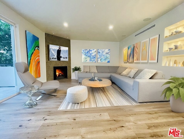 living room with a large fireplace and hardwood / wood-style flooring