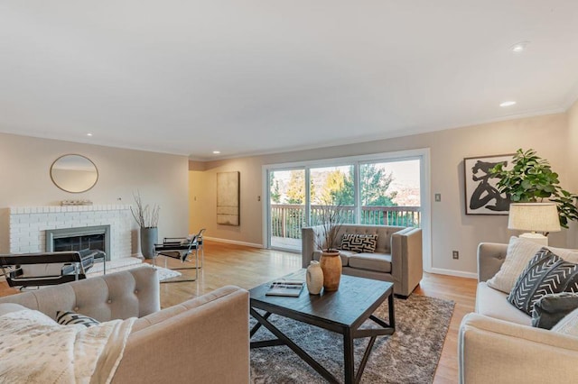 living room with a brick fireplace and light hardwood / wood-style floors