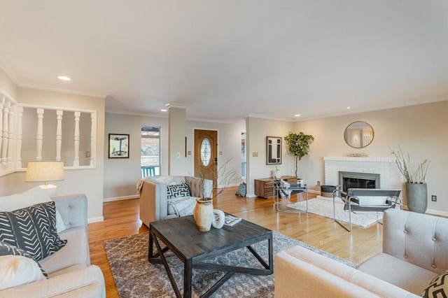 living room featuring ornamental molding, a brick fireplace, and light wood-type flooring