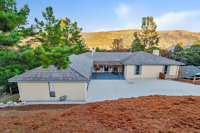 view of front facade with a patio and a mountain view