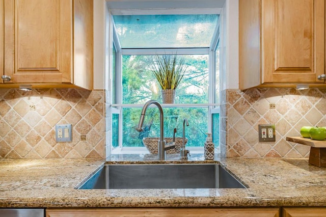 kitchen with sink, backsplash, and light stone counters