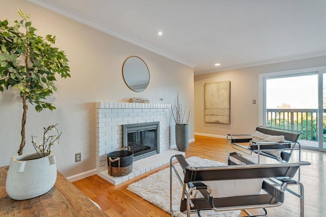 living room featuring crown molding, a fireplace, and light wood-type flooring