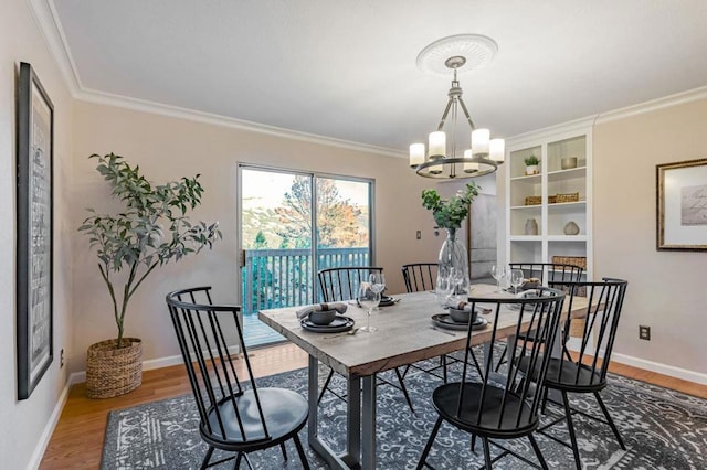 dining room with hardwood / wood-style floors, crown molding, and a chandelier