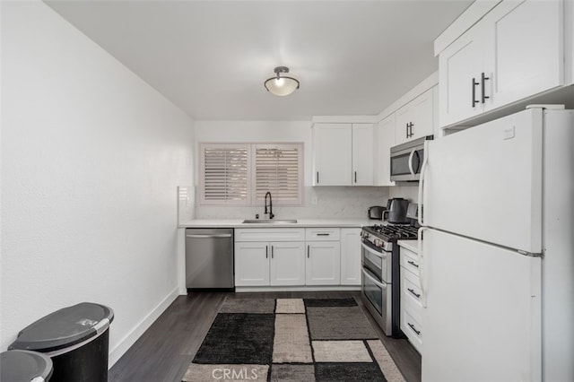 kitchen featuring white cabinetry, sink, dark hardwood / wood-style floors, and appliances with stainless steel finishes