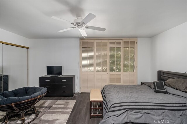 bedroom with ceiling fan, dark wood-type flooring, and a closet