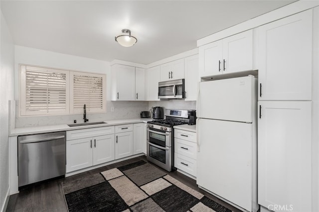 kitchen with white cabinets, dark hardwood / wood-style flooring, sink, and stainless steel appliances