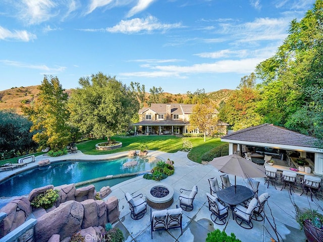 view of pool with a patio, a yard, and an outdoor bar