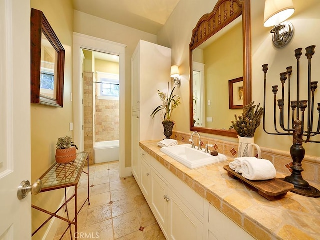 bathroom featuring tiled shower and vanity