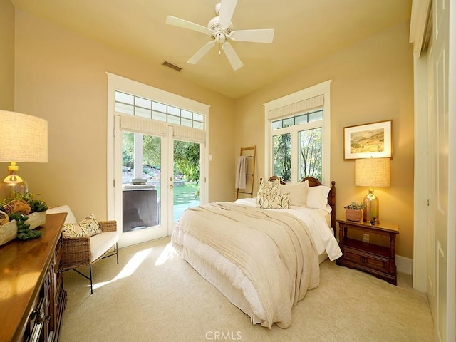 bedroom featuring access to outside, multiple windows, ceiling fan, and light colored carpet