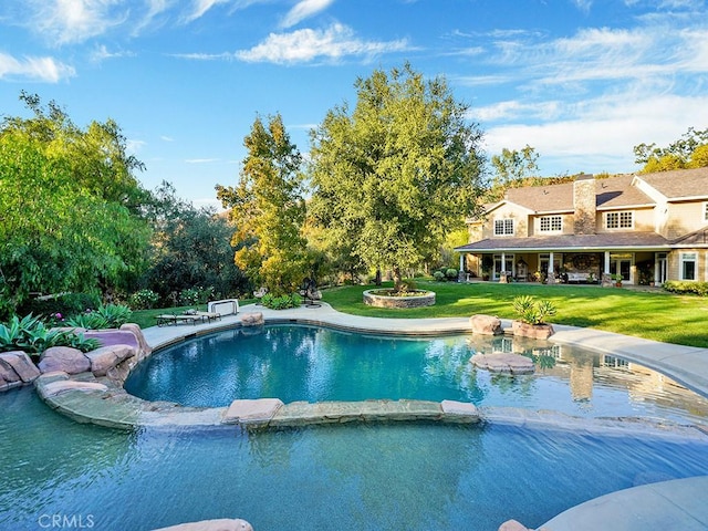 view of swimming pool with a lawn