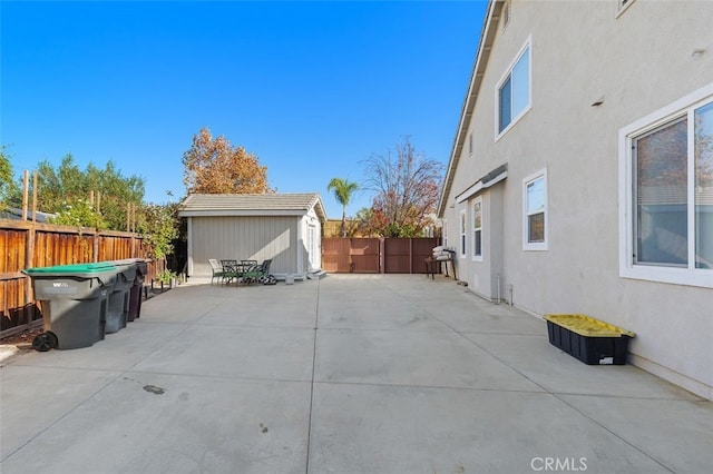 view of side of property with a patio and a shed