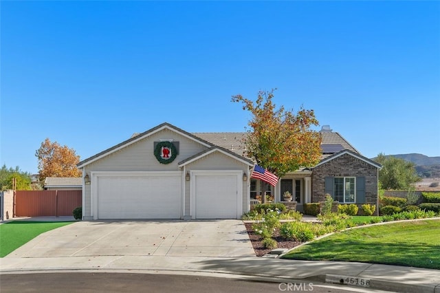 view of front of house featuring a mountain view, a front yard, and a garage