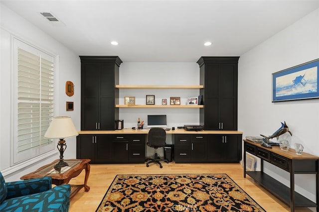 office space featuring light wood-type flooring and built in desk