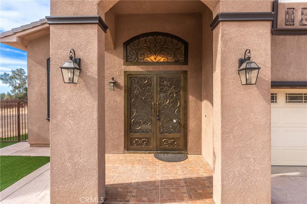 entrance to property with a garage and stucco siding