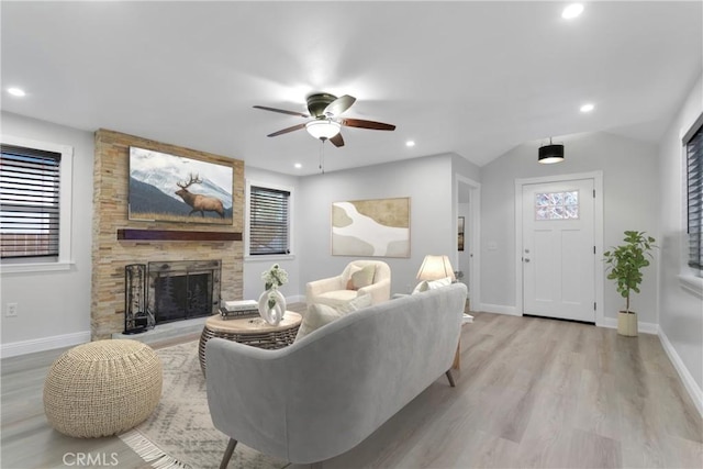 living room with lofted ceiling, light wood-type flooring, plenty of natural light, ceiling fan, and a fireplace