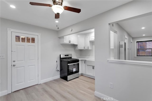 kitchen featuring gas range, white cabinetry, and light wood-type flooring