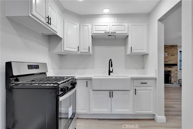 kitchen featuring stainless steel gas range oven and white cabinets