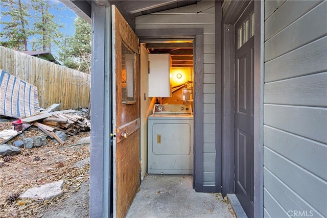 clothes washing area with washer / dryer and wood walls