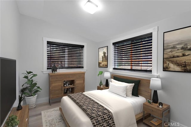 bedroom featuring lofted ceiling and light wood-type flooring