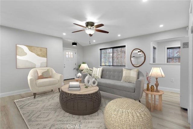 living room featuring light hardwood / wood-style floors and ceiling fan