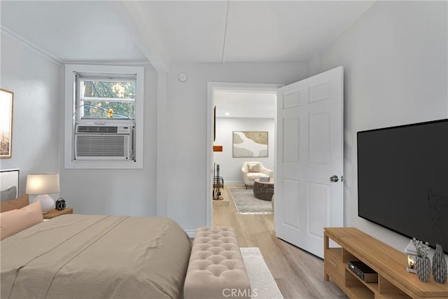 bedroom with cooling unit and light hardwood / wood-style floors