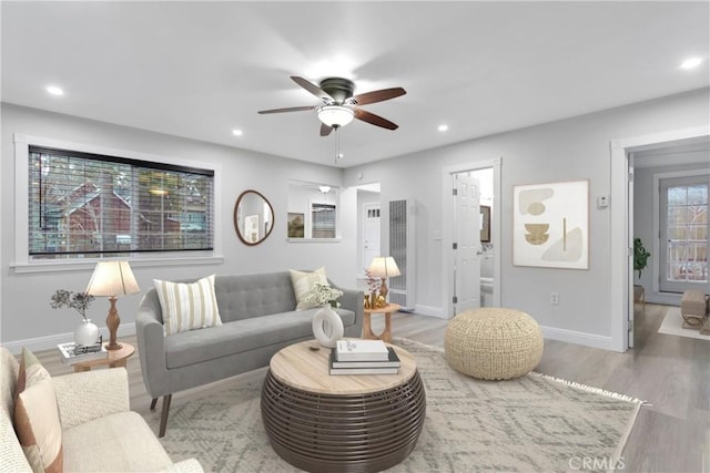 living room with ceiling fan and light hardwood / wood-style floors