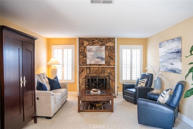 living room featuring a stone fireplace and light colored carpet