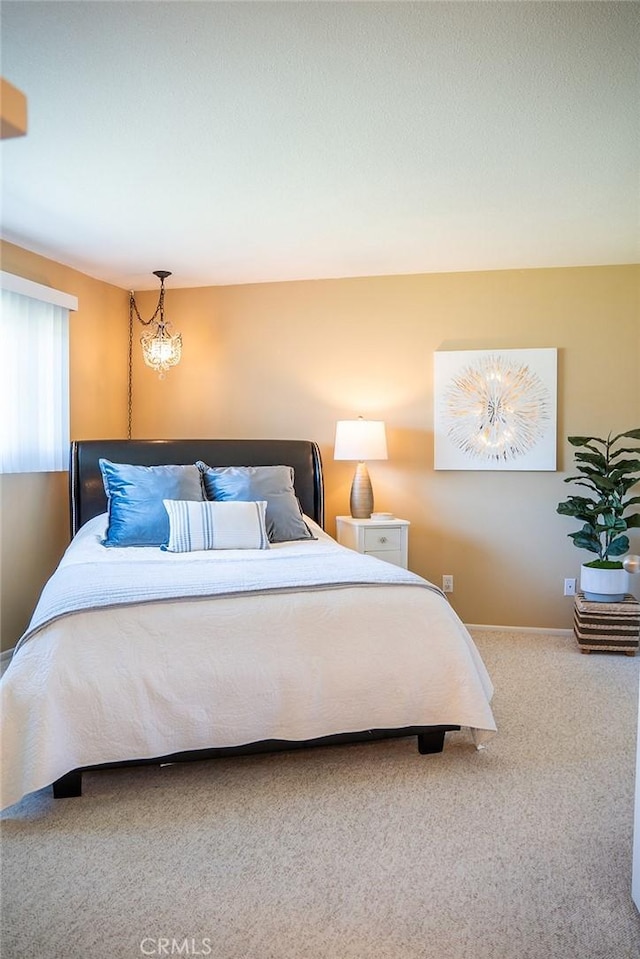 bedroom with carpet and an inviting chandelier