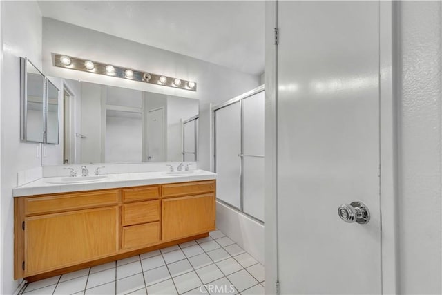 bathroom featuring tile patterned flooring, vanity, and bath / shower combo with glass door