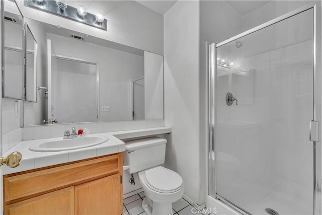 bathroom with tile patterned flooring, vanity, toilet, and a shower with shower door