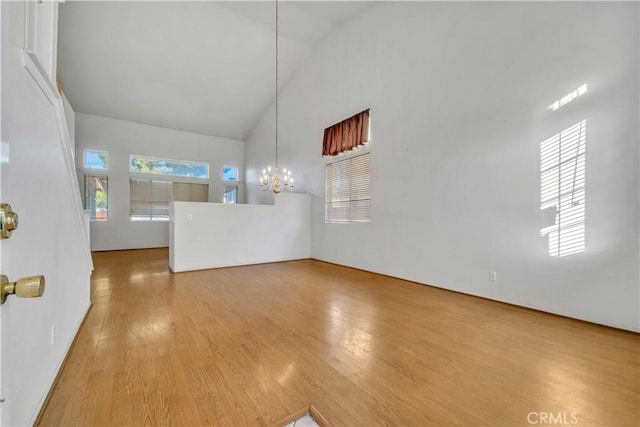 interior space featuring hardwood / wood-style flooring, high vaulted ceiling, and a notable chandelier