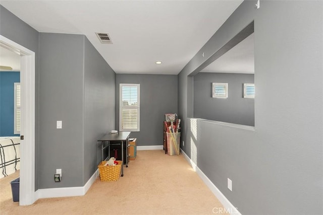 hallway featuring light colored carpet