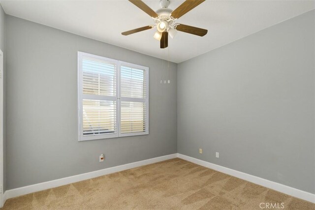 spare room with light colored carpet and ceiling fan