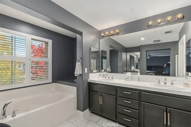 bathroom featuring vanity and tiled tub