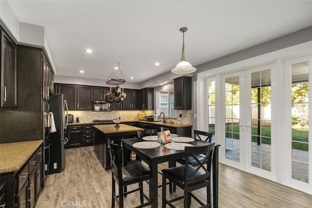 kitchen featuring light hardwood / wood-style floors, french doors, a healthy amount of sunlight, and appliances with stainless steel finishes