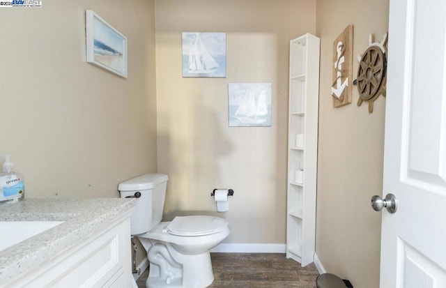 bathroom with toilet, wood-type flooring, and vanity