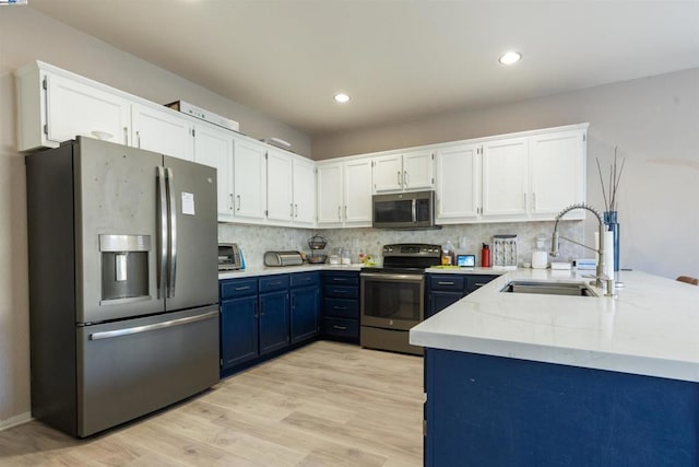 kitchen featuring white cabinets, stainless steel appliances, sink, light hardwood / wood-style flooring, and blue cabinets