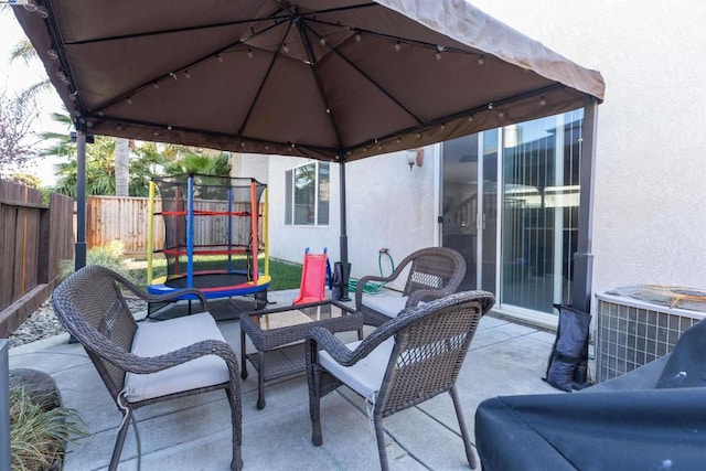 view of patio / terrace with central AC unit, a gazebo, and a playground