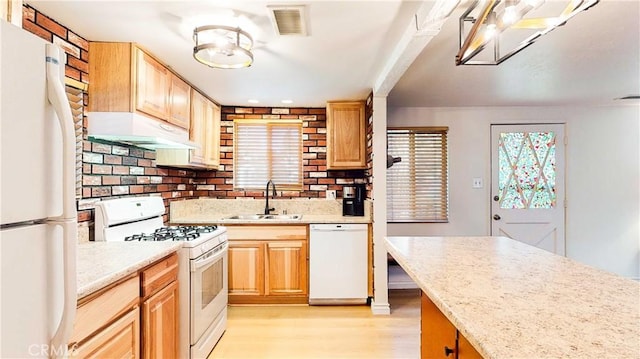 kitchen with sink, light stone counters, light hardwood / wood-style floors, white appliances, and light brown cabinetry