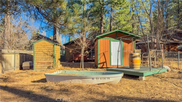 view of playground with an outdoor structure, a fenced backyard, and a storage shed