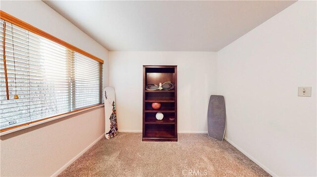 empty room featuring carpet floors and baseboards