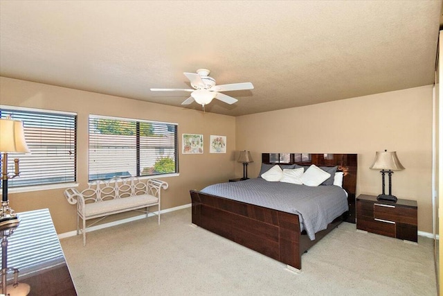 bedroom featuring a textured ceiling, ceiling fan, and light carpet