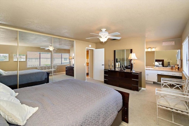 bedroom with ceiling fan, built in desk, and a textured ceiling