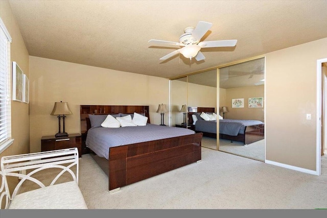 bedroom with light carpet, multiple windows, a closet, and ceiling fan