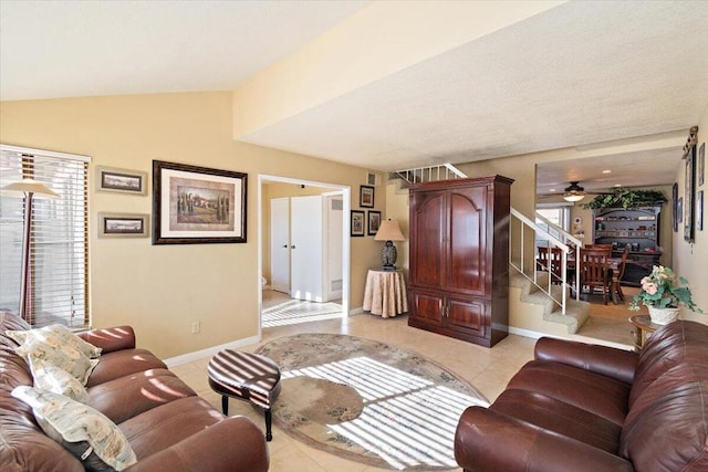 tiled living room with ceiling fan and vaulted ceiling