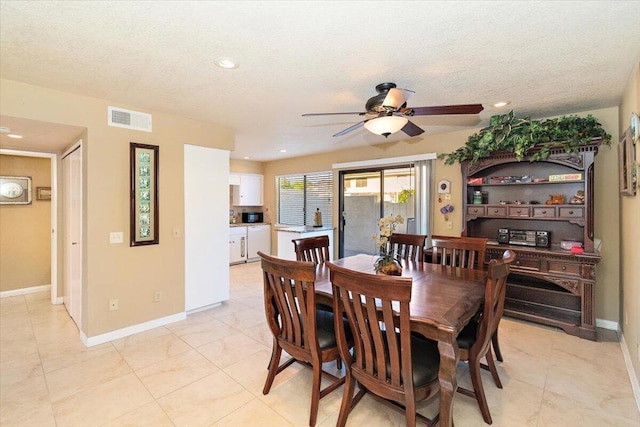 tiled dining area with ceiling fan and a textured ceiling