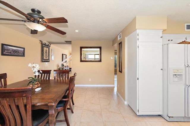 dining room featuring ceiling fan and a textured ceiling