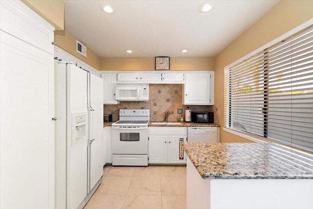 kitchen featuring light stone countertops, white appliances, white cabinetry, and sink