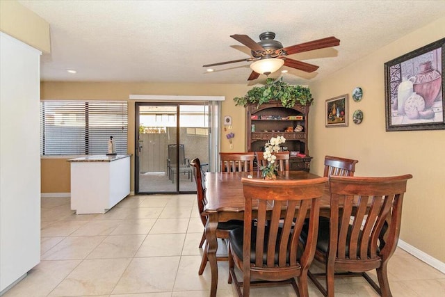 tiled dining room with ceiling fan and a textured ceiling